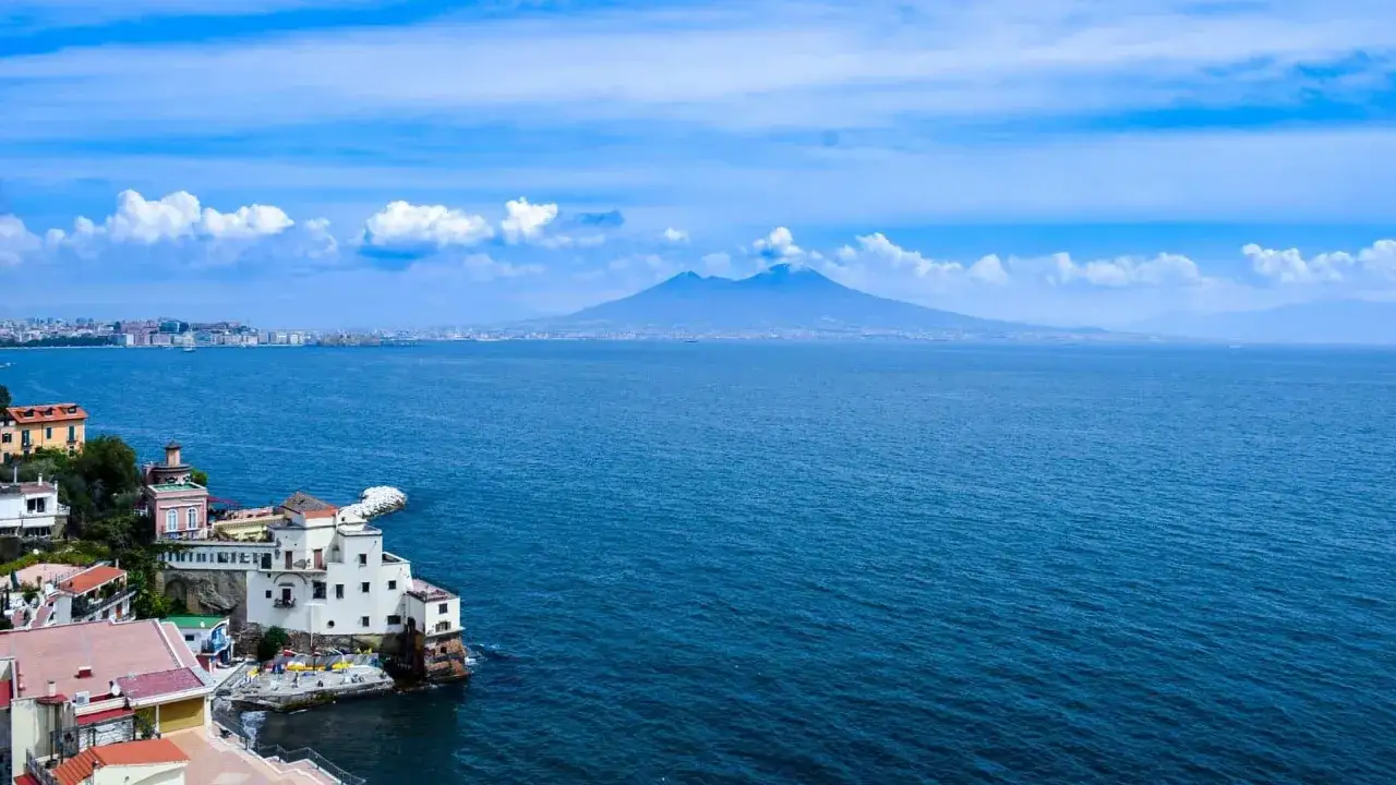 Vista panoramica del Vesuvio e del golfo, con case a picco sul mare che ricordano le isole vicino Napoli.