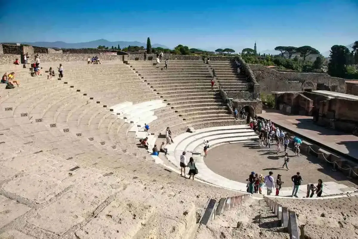 L'anfiteatro di Pompei, un luogo imperdibile per chi visita la citt&agrave;. Turisti esplorano le antiche gradinate sotto un cielo azzurro.