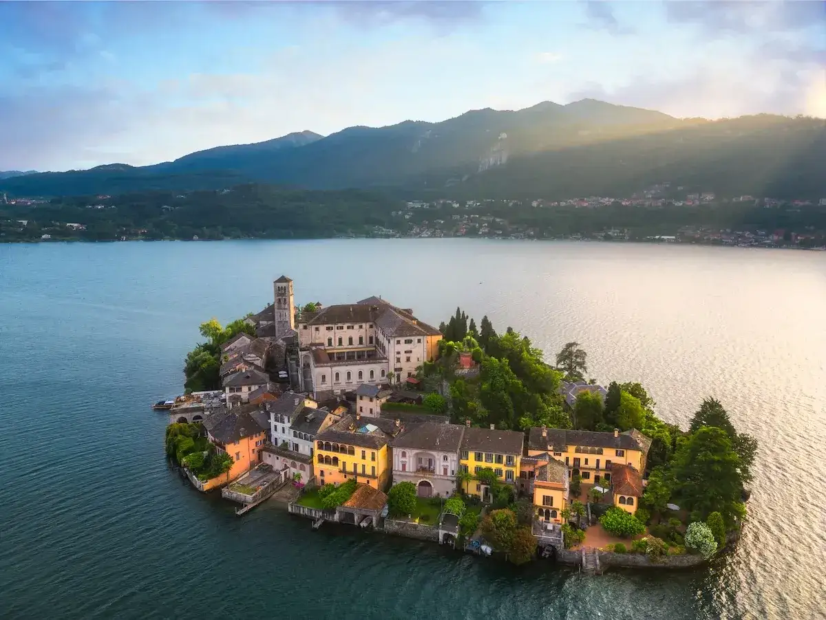 Isola di San Giulio, uno dei borghi da visitare in Piemonte, incastonata nel lago d'Orta, con case colorate e un'antica basilica.