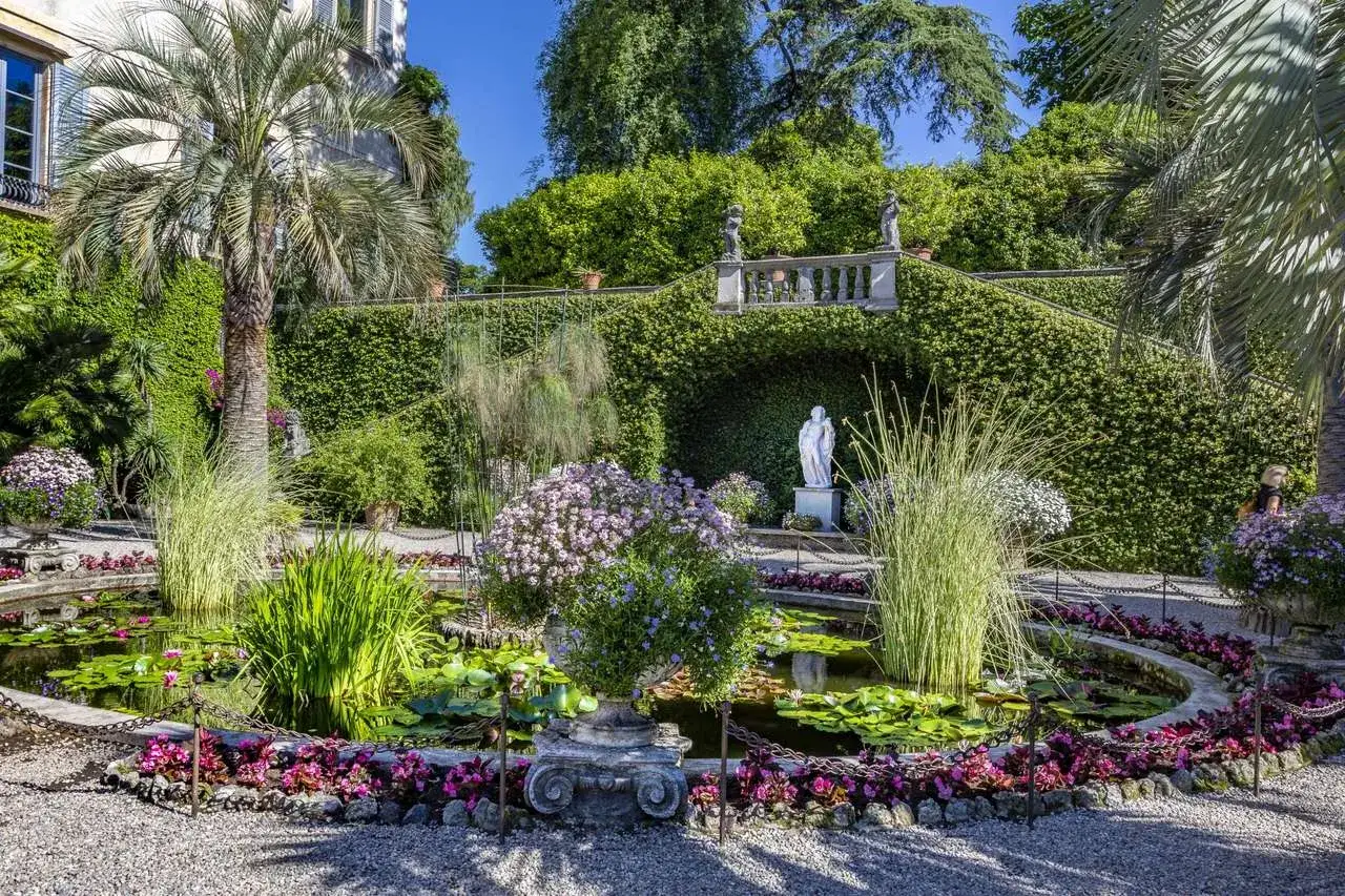 Giardini lussureggianti e stagno fiorito, con statue e palme. Ecco cosa vedere a Isola Madre per un'esperienza indimenticabile.
