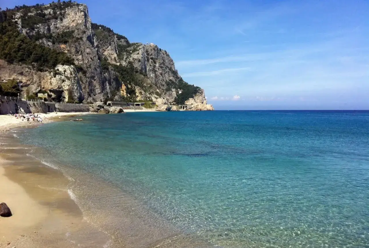 Spiaggia con mare cristallino e scogliere a picco, un luogo ideale per percorrere il sentiero del pellegrino.