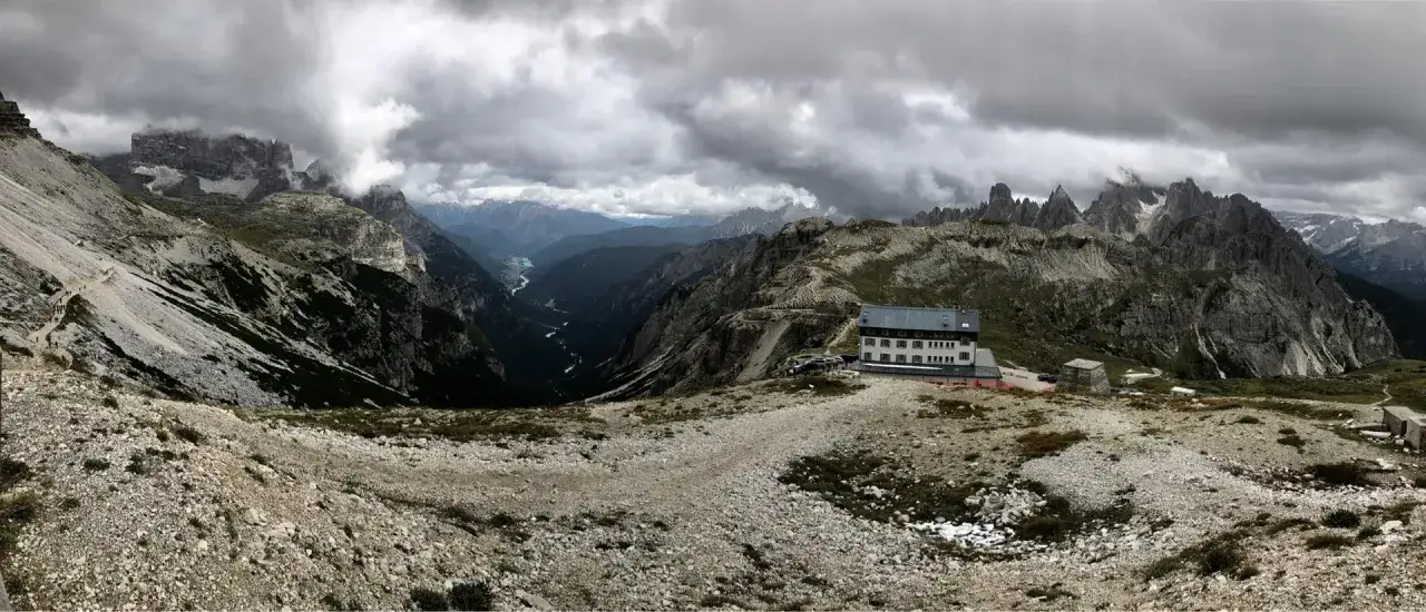 Un rifugio alpino in Veneto, incastonato tra imponenti vette rocciose e una valle profonda. Un luogo ideale per chi cerca avventura e panorami mozzafiato.