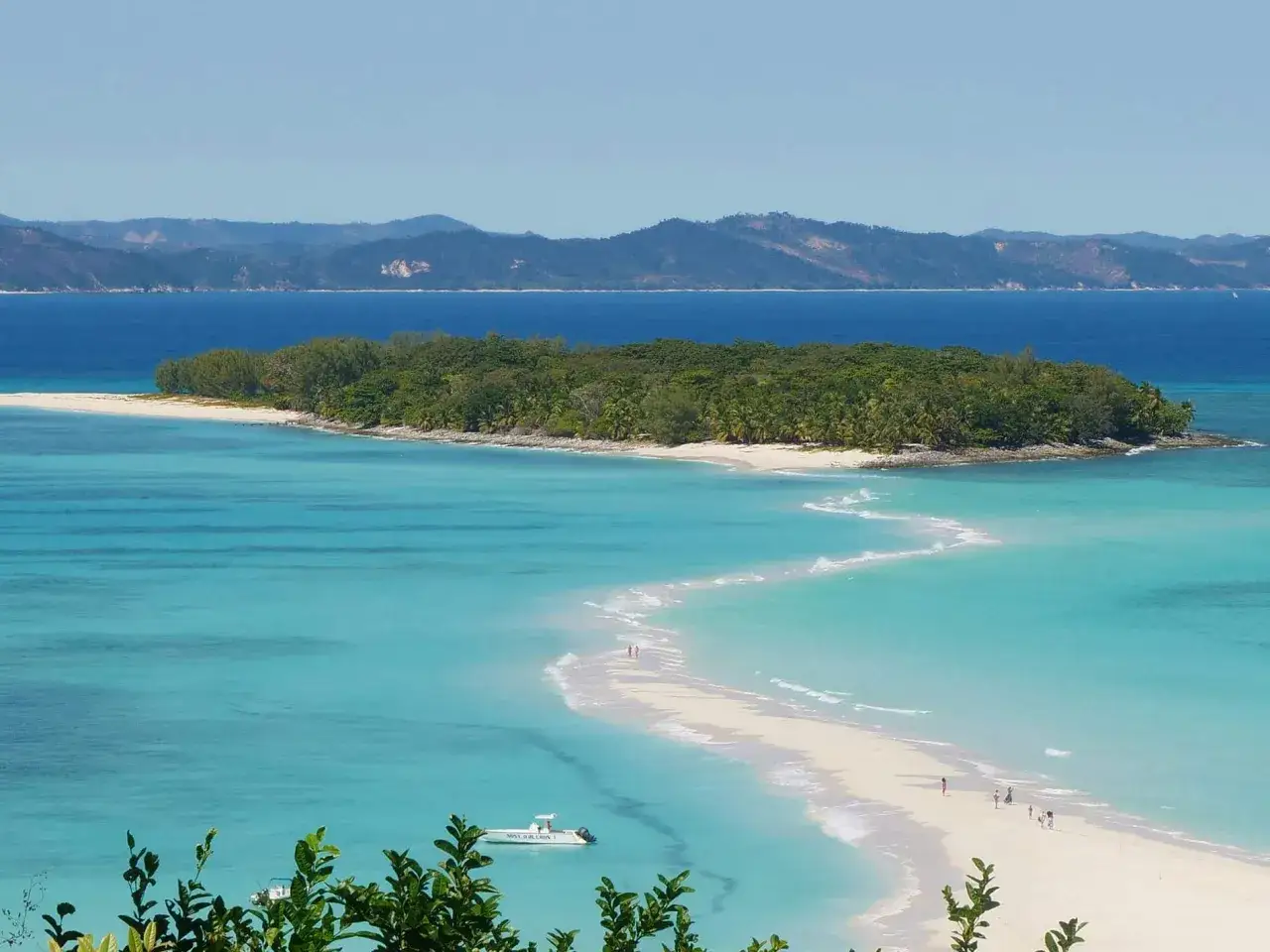 Spiaggia bianca a forma di lingua di sabbia, acque turchesi cristalline, isole verdi e montagne all'orizzonte. Perfetto per sapere dove andare al mare a novembre.