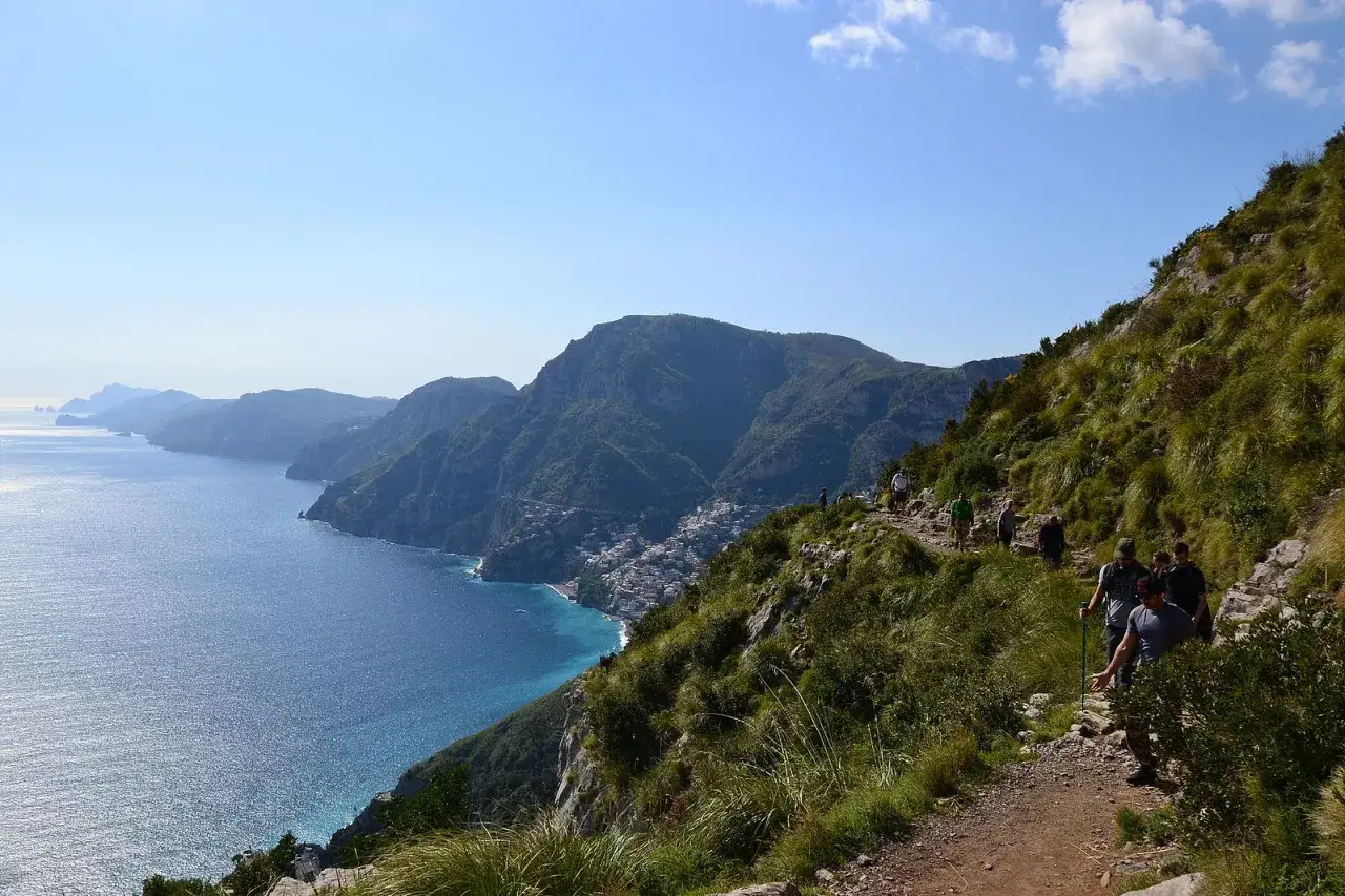 Escursionisti sul sentiero degli dei, con vista mozzafiato sulla costa amalfitana e il mare blu intenso.