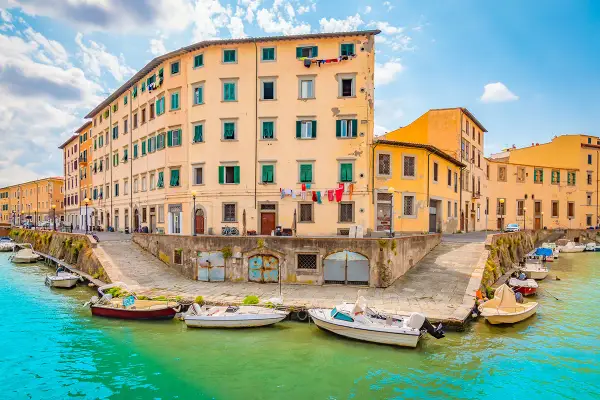Canali di Livorno, un'idea per cosa vedere a Livorno in un giorno. Case colorate e barche sull'acqua turchese.
