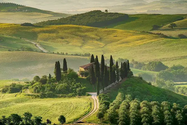 Colline toscane con cipressi e casale, un'immagine iconica dei borghi da visitare in Toscana.