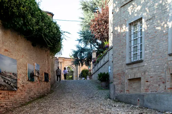 Passeggiata nel centro storico di Neive, tra antiche mura ricoperte d'edera e opere d'arte esposte all'aperto.