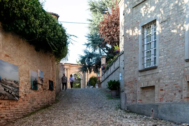 Passeggiata nel centro storico di Neive, tra antiche mura ricoperte d'edera e opere d'arte esposte all'aperto.