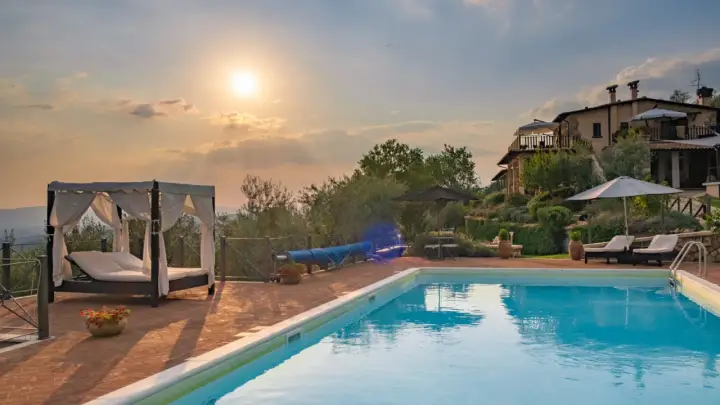 Piscina e lettini in una delle splendide tenute in Toscana al tramonto.